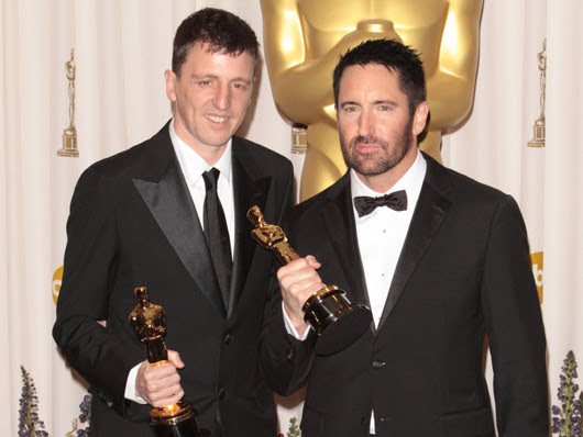 Atticus Ross and Trent Reznor holding their Oscars
