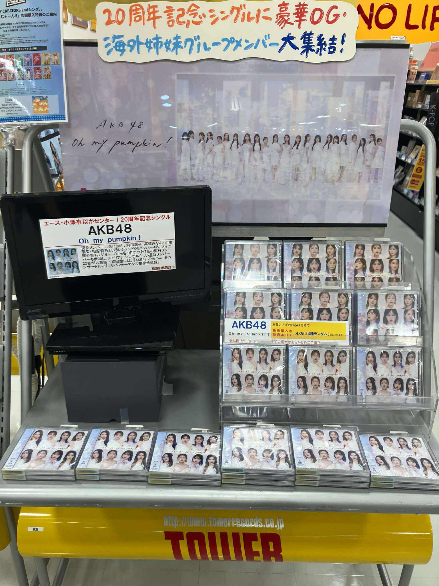 photo of a store display for AKB48 CDs in a Tower Records shop. There is a small TV amongst the CDs that is switched off and has a promotional banner stuck to the screen
