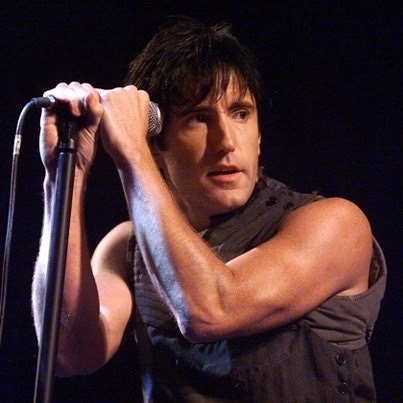 image of trent Reznor with short hair holding a microphone on the fragility tour.