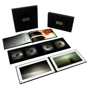 photo of the deluxe version of Ghosts I-IV showing: 2 CDs, a DVD-ROM, Blu-ray Disc, hardcover 48-page book in a black fabric slipcase, 4 vinyl records, and 2 art prints. 
