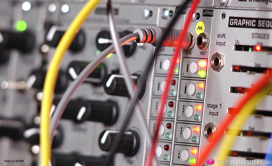 a close up photo of an analog synth showing its cables and dials