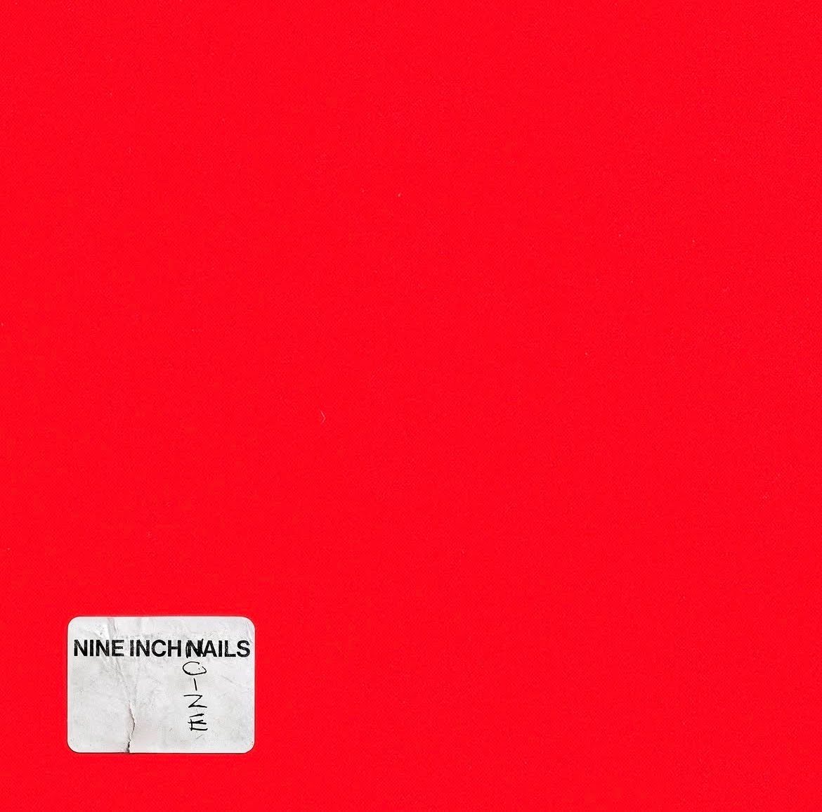 red square with a white sticker in the bottom left corner. Printed on the sticker in black is NINE INCH NAILS, oize is written vertically benath the N of Nails in black pen