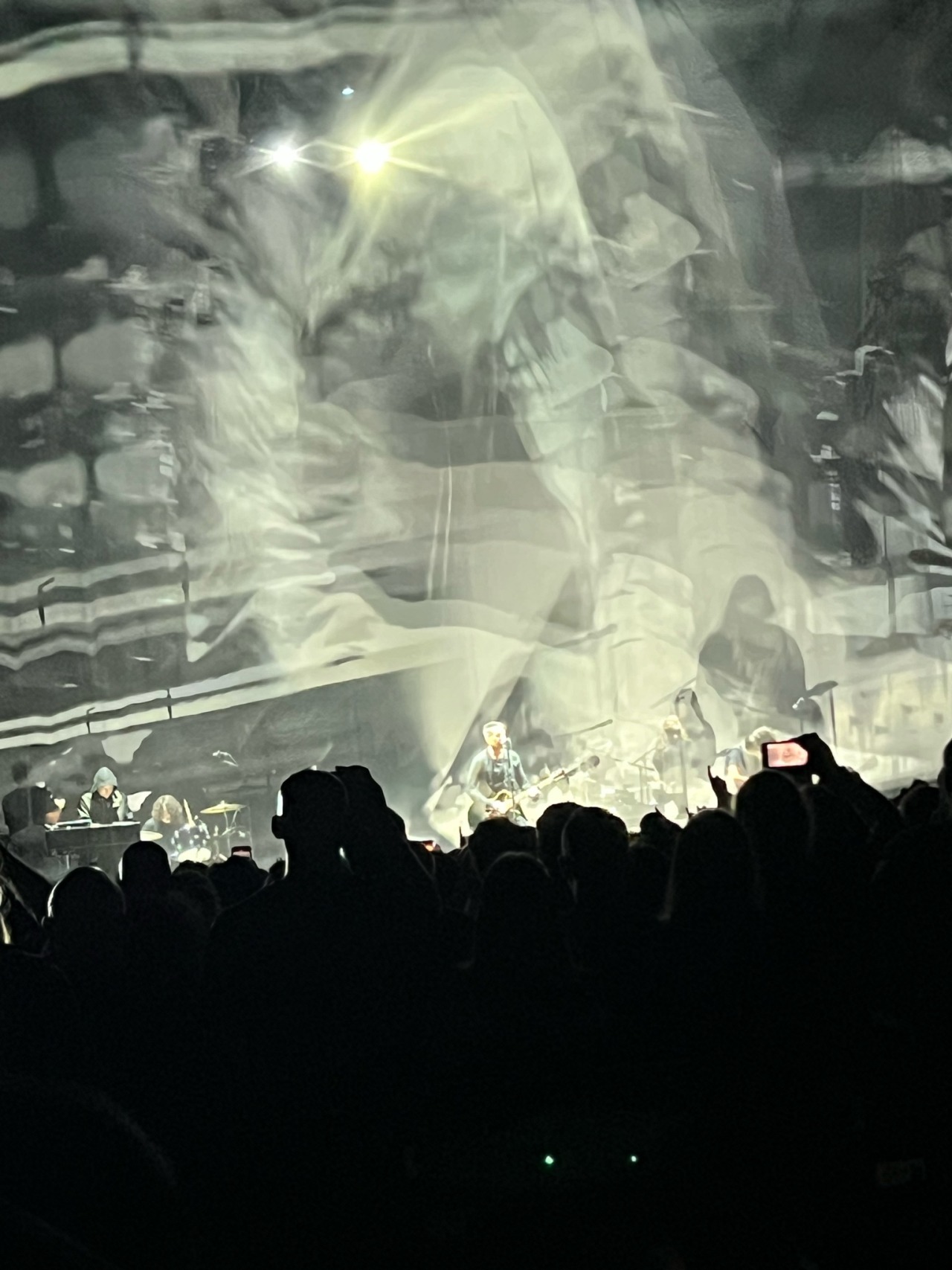 photo of NIN performing reptile on stage surrunded by white and green swirling projections.