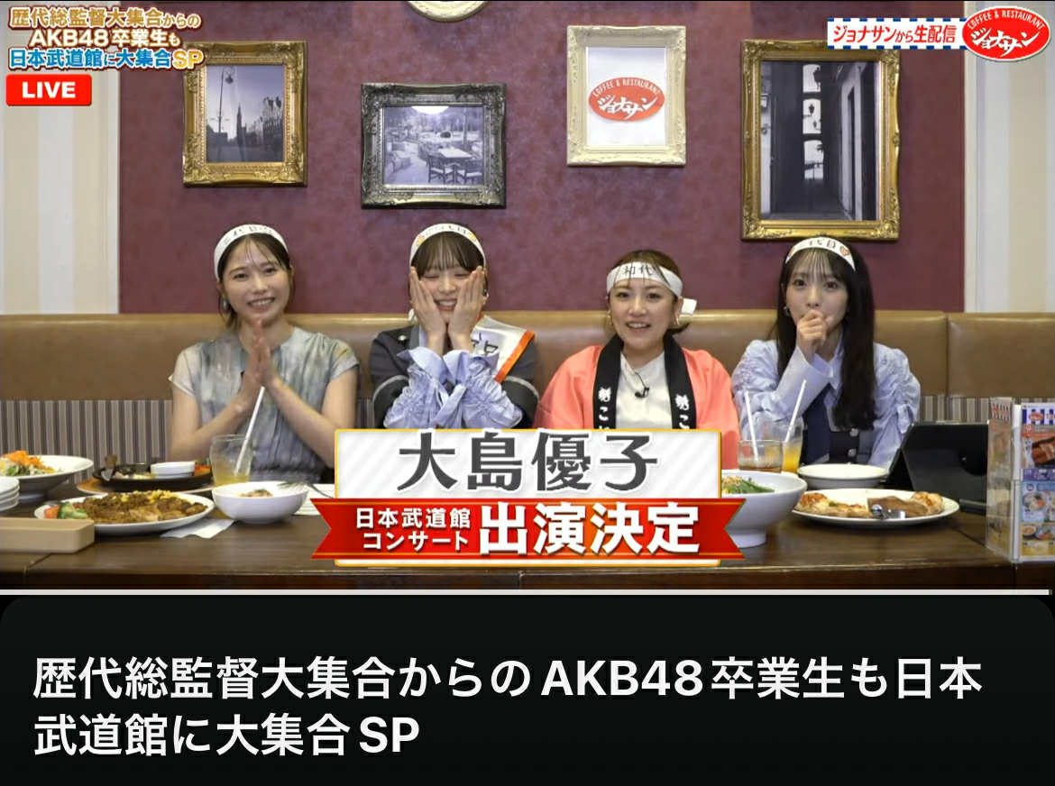 Screenshot of the livestream showing Yui Yokoyama, Narumi Kuranoo, Minami Takahashi and Mion Mukaichi sat at a resturant table. The text on screen says Yuko Oshima will be appearing at the Nippon Budokan Concert