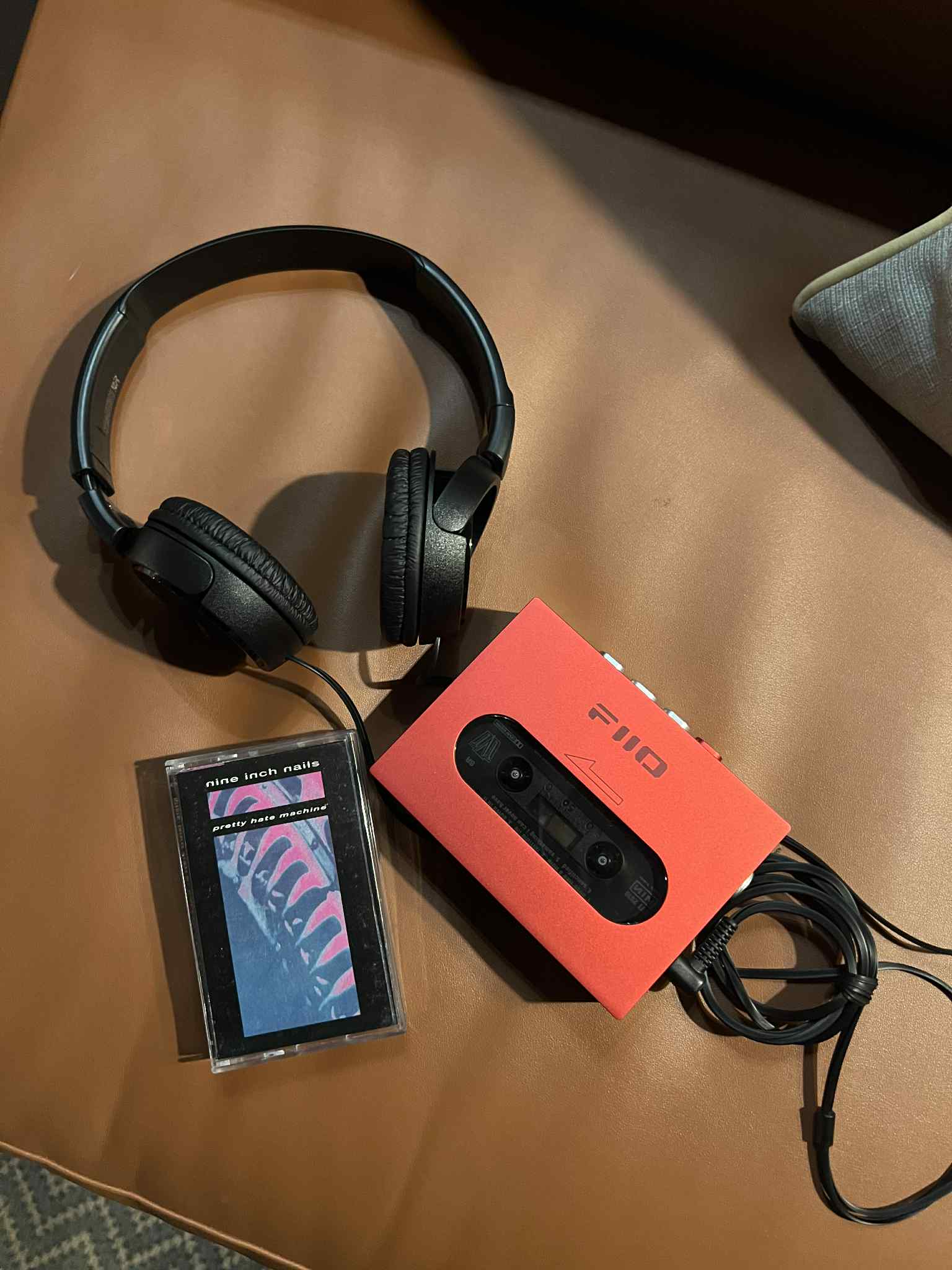 Pretty Hate Machine cassette tape with black headphones and a red tape player