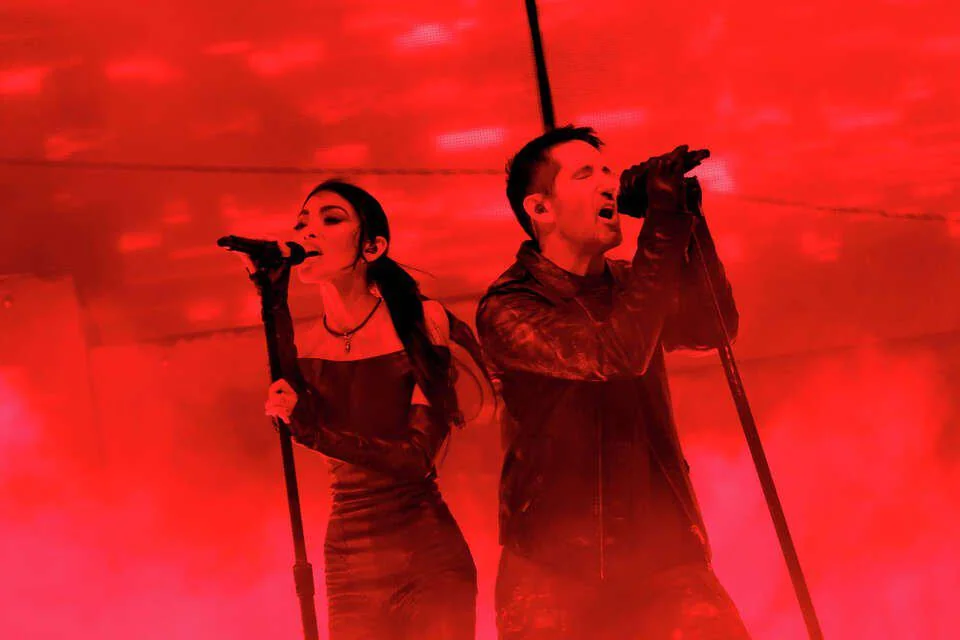 photo of trent and mariqueen reznor singing bathed in red light